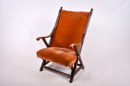 A 20th century mahogany 'x' frame armchair.