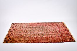 A Persian style red ground wool rug.