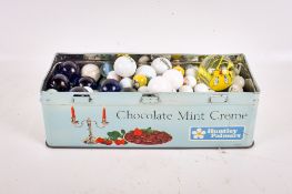 A collection of 20th century glass marbles. Various colours and sizes, in a tin.