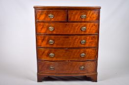 A Victorian inlaid mahogany bow fronted chest of drawers.