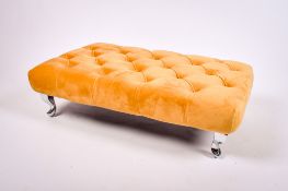 A contemporary button yellow upholstered footstool. Raised on chrome cabriole supports.