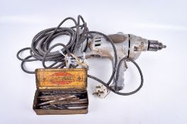 A circa 1950s Wolf Tools electric drill and a tin of bits.