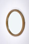 A 20th century circular bevelled edge wall mirror. Having a textured metal frame, Diameter 40.5cm.