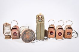 A collection of vintage road lanterns, a jerry can lamp, and a paraffin heater.