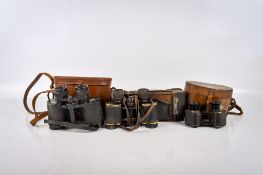 Three pairs of vintage binoculars and a bellows camera.