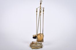 A set of three fire irons on a stand. Raised on a circular base.