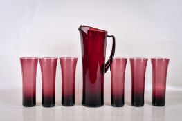 A mid-century hand blown amethyst glass pitcher and six beaker drinking set.