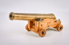 A bronze model of a ship's cannon on a wooden carriage.
