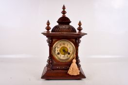 An early 20th century Temple style walnut cased mantel clock.
