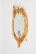 A 19th century giltwood and gilt-gesso oval wall mirror.