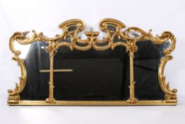 A large 19th century French Louis XV Rococo style giltwood framed wall mirror.