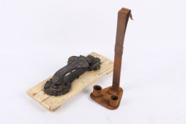 A late 19th century door knocker and a candle holder.