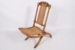 A Victorian folding campaign chair with barley twist columns.