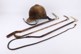 Three vintage horse riding crops and a Camelot Saddlery Ltd helmet.