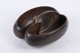 A large Coco de Mer nut carved as a basket. With central handle retained, undecorated, L31cm.