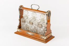 A Victorian silver plated three bottle oak tantalus.