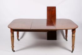 A Victorian mahogany extending dining table with two leaves.