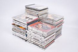 A collection of approximately 60 assorted CDs, mostly 1970s and 80s pop music.