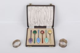 A set of six silver and enamel teaspoons and two silver napkin rings.