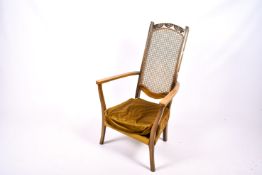 An early 20th century high, cane work back open arm chair.
