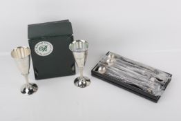 A set of six white metal spoons and a pair of silver plated beakers.