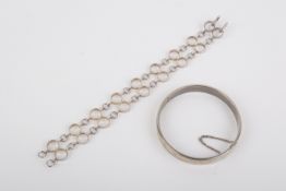 A silver loop bracelet and a white metal bangle.