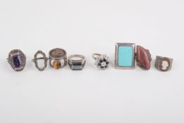 Eight stone set silver, white metal and yellow metal rings.