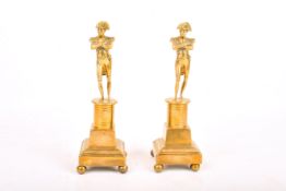 Two brass figures modelled as 'Nelson'. Raised on a stepped square plinth.