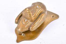 A vintage brass door knocker. Modelled as a dog's head against a shield base, H14cm.