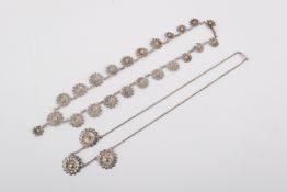 Two white metal floral necklaces. One featuring three moulded flower charms on a chain, 6.