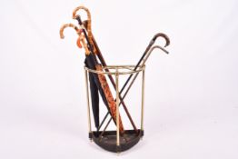 A modern brass stick stand H58cm with a collection of assorted walking sticks and unbrellas.