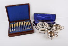 A three-piece silverplated tea set and silverplated boxed cutlery.