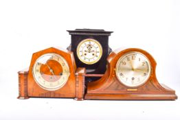 A group of three assorted mantel clocks.
