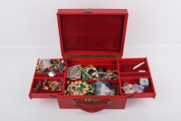 A collection of assorted costume jewellery in a red leather jewellery box.