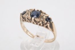 A 9ct gold, sapphire and diamond ring. Set with three sapphires of circa 0.