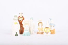 Seven Royal Worcester porcelain candle snuffers and a Royal Doulton figure.