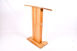 A modern light mahogany lectern stand.