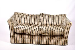 A contemporary two-seater low back sofa with stripped upholstery.