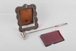 A Victorian silver photograph frame and a silver plated candle snuffer.