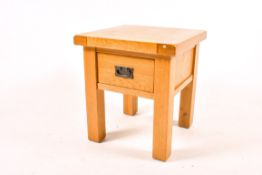 A modern solid light oak occasional table, fitted with a single drawer.