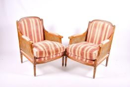 A pair of French bergere mahogany style armchair with stripped upholstery.