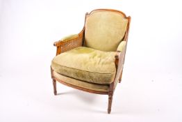 A French Bergere mahogany style armchair with green upholstery.