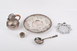 Five silverplated and metal items. Including a rounded jug, pierced round tray, serving spoon, etc.