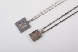 Two silver necklaces and pendants.