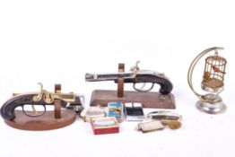 A collection of novelty cigarette lighters. Including a bird cage and three pistols, etc.