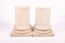 A pair of contemporary faux marble resin column bases raised on a square plinth.