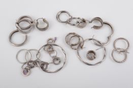 A small group of silver and white metal earrings.