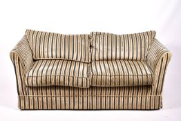 A contemporary two-seater low back sofa with stripped upholstery.