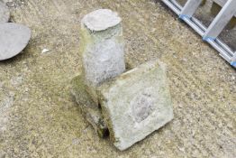 A composite stone bird bath on pedestal with square base and top.