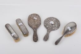 Five silver backed dressing table items.